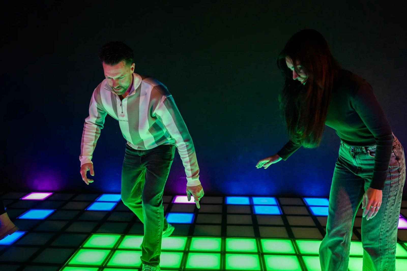 Two players on the interactive light-up game floor